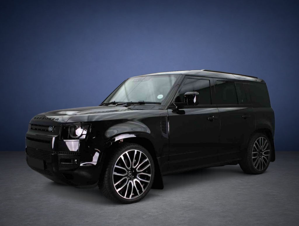 Close-up of a black luxury SUV showing the front grille and wheel against a dark blue background.