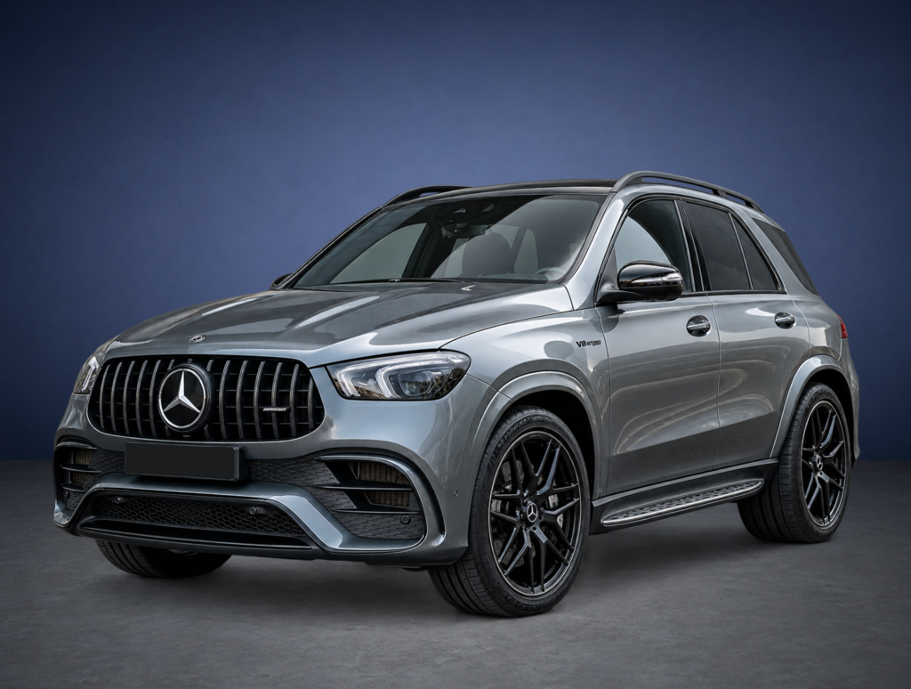 Front three-quarter view of a silver Mercedes-Benz SUV with a prominent grille and large alloy wheels against a dark blue backdrop.